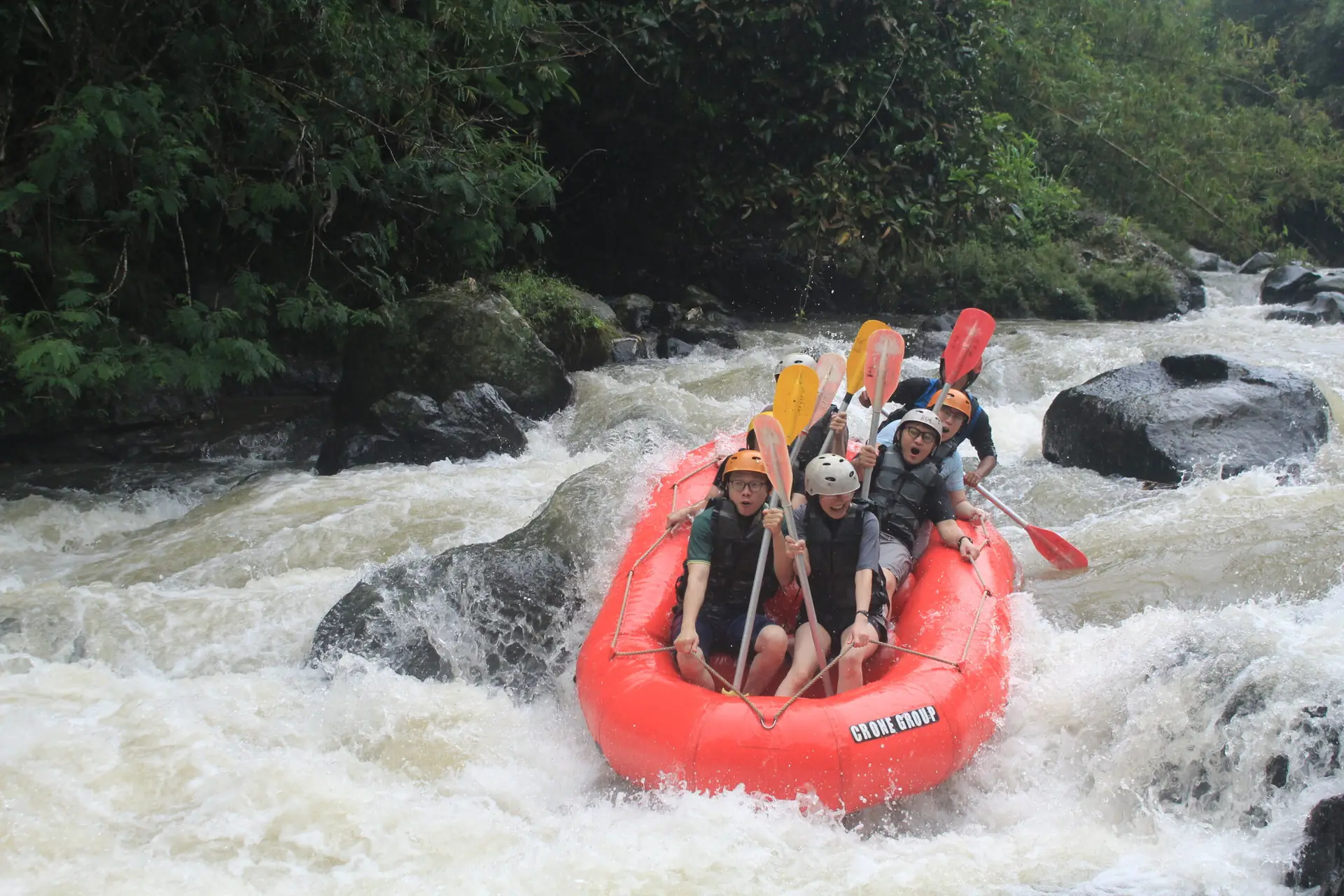 Perahu kuning melintas di bawah tebing batu