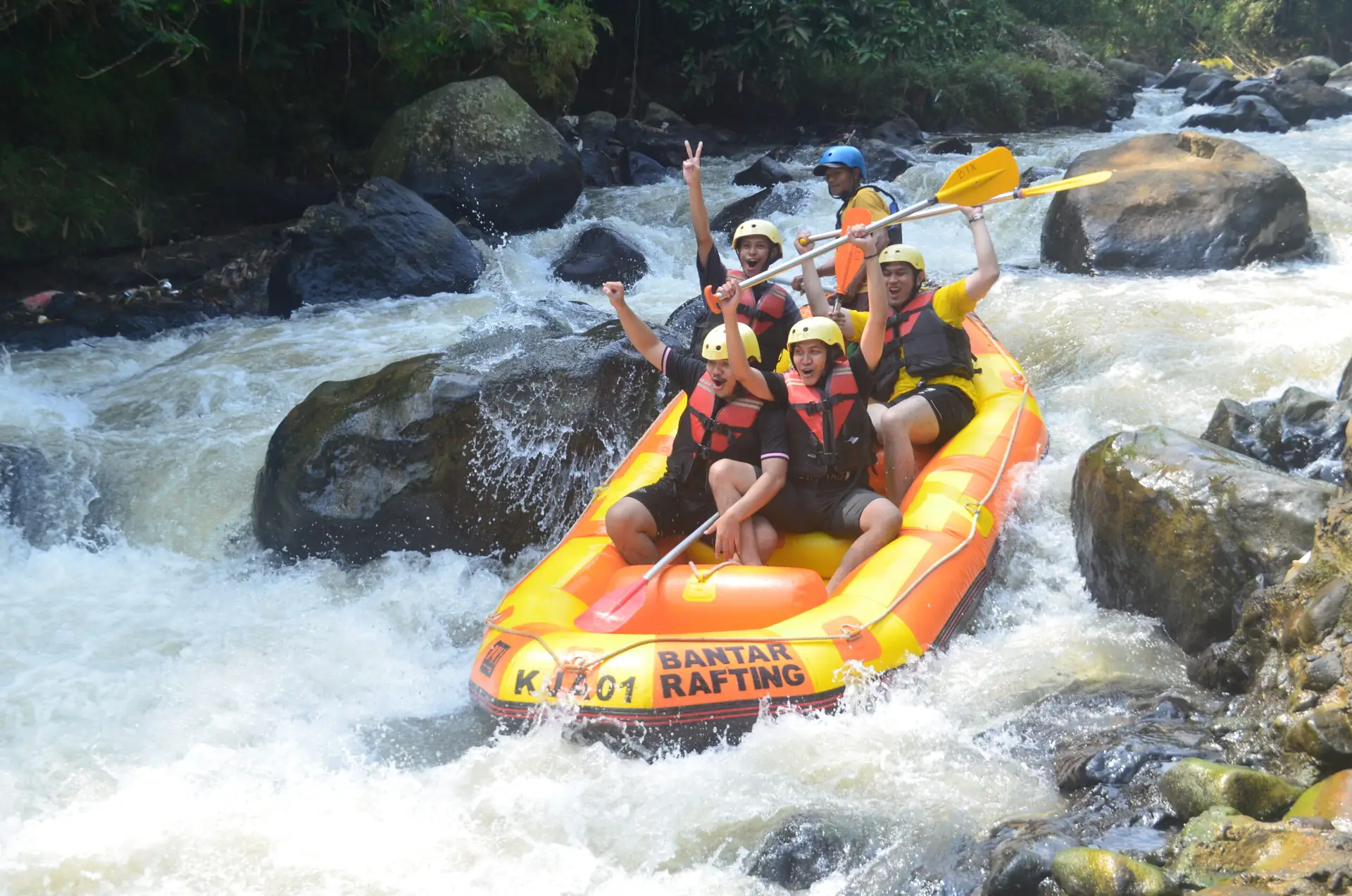 Perahu merah menuruni bendung kecil dengan air melimpah