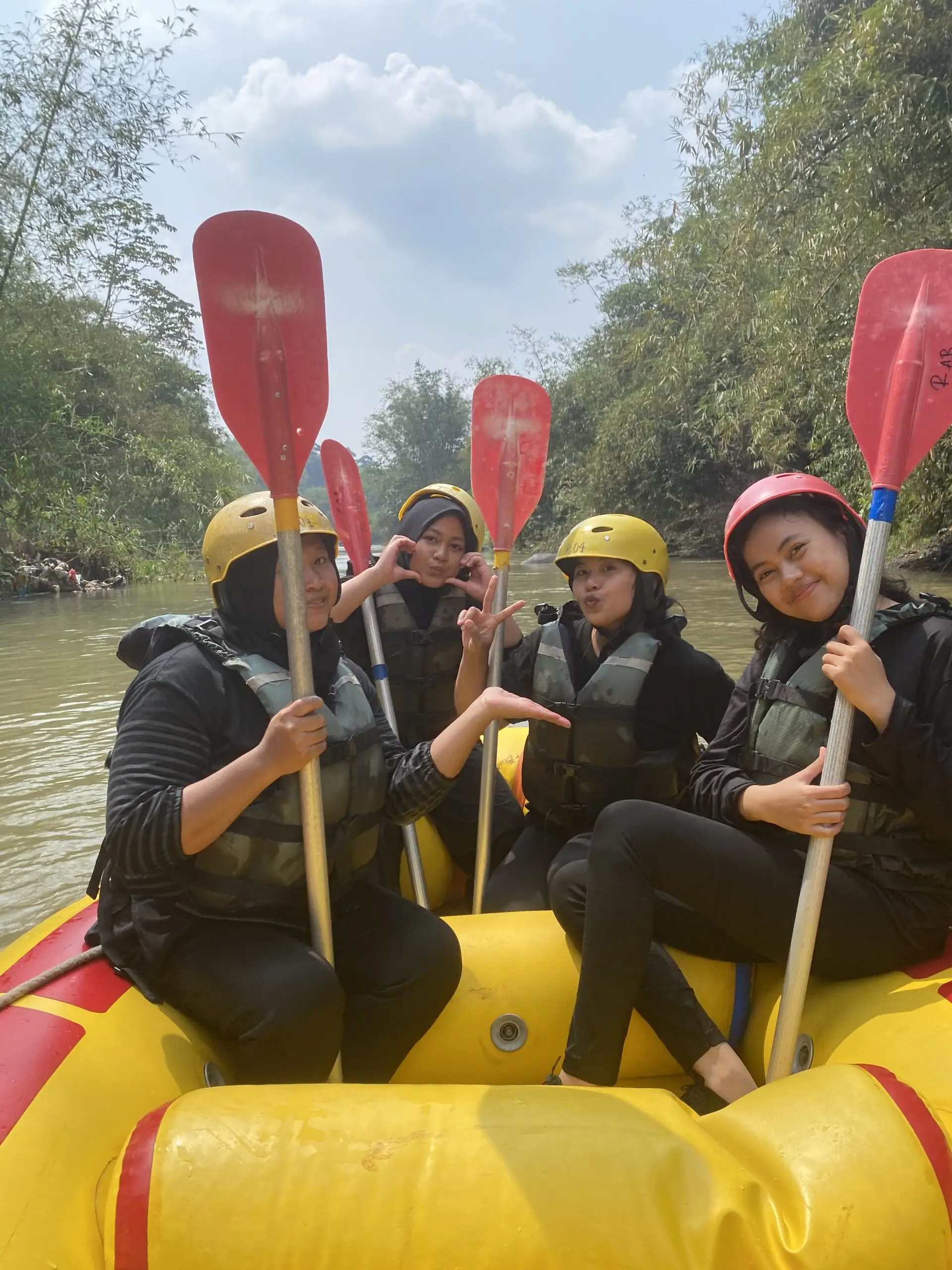 Peserta berfoto bersama di dalam perahu kuning di tepi sungai